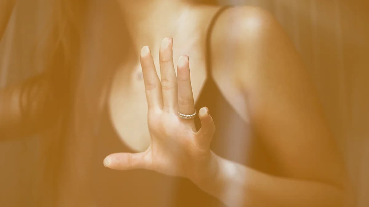 A woman with her hand pressed against a window